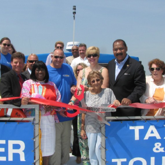 Group posing for a photo while cutting ribon